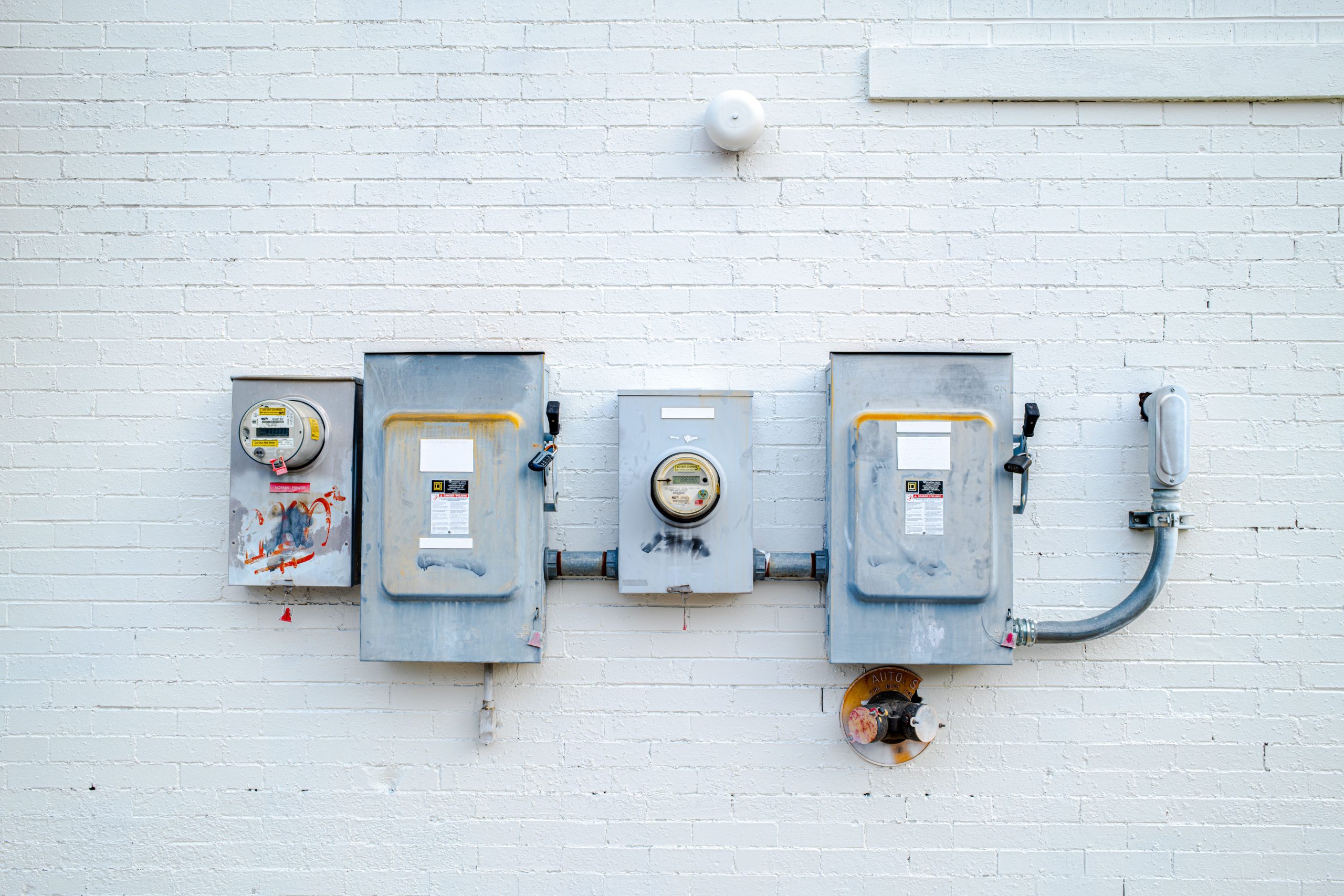 Boîtiers électriques et compteurs sur mur blanc
