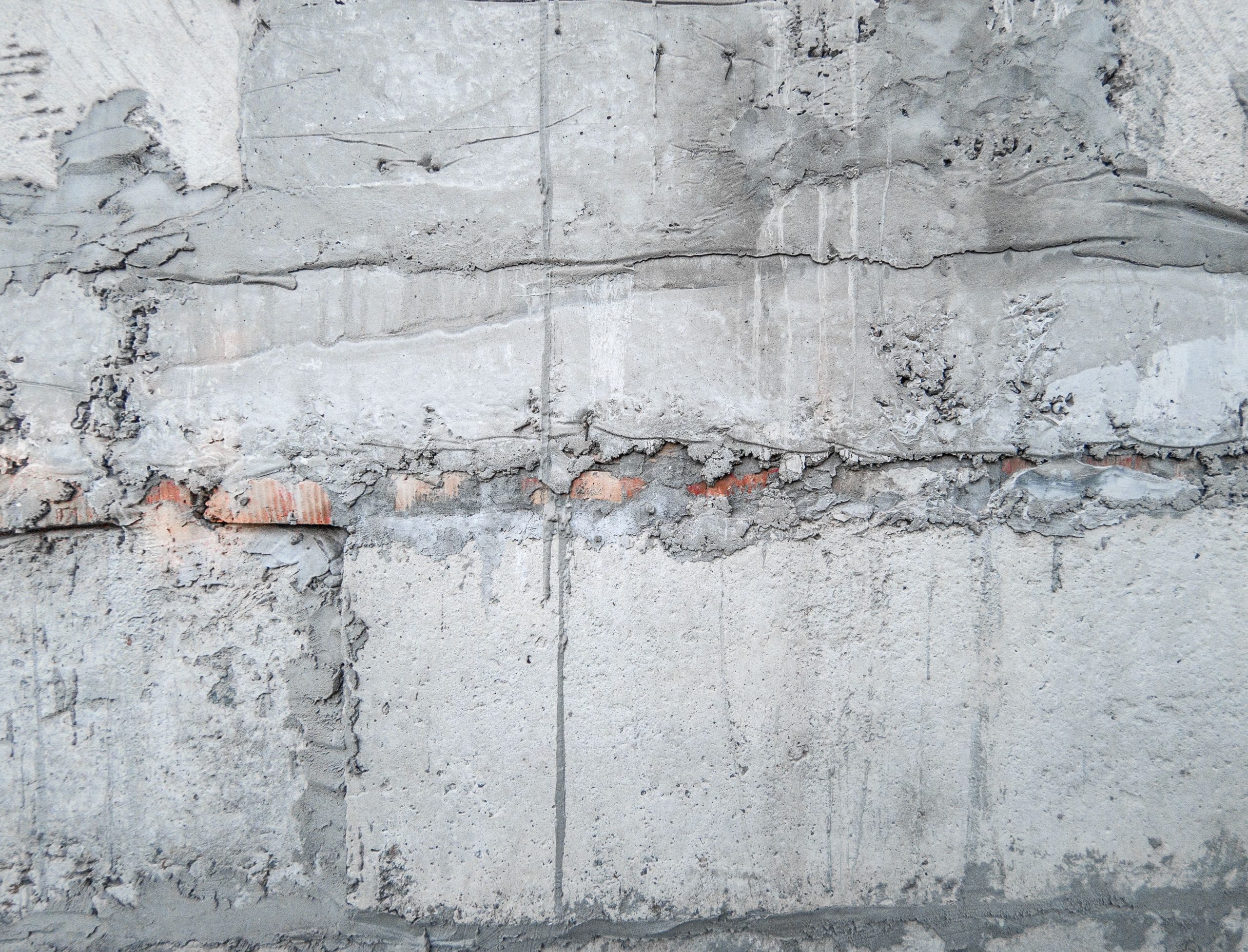 Mur ancien en pierre et enduit gris patiné