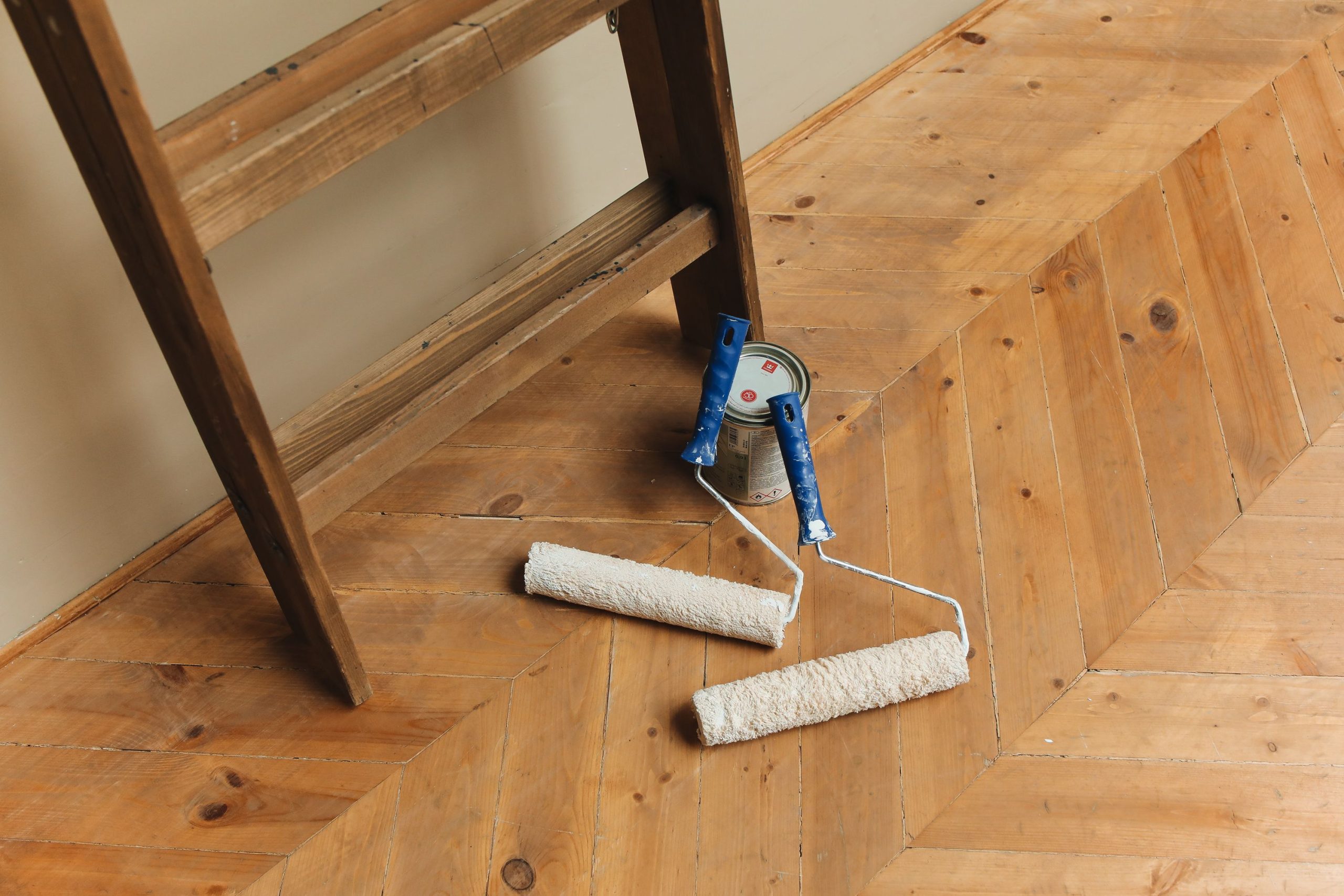 Rouleaux peinture et echelle sur sol bois