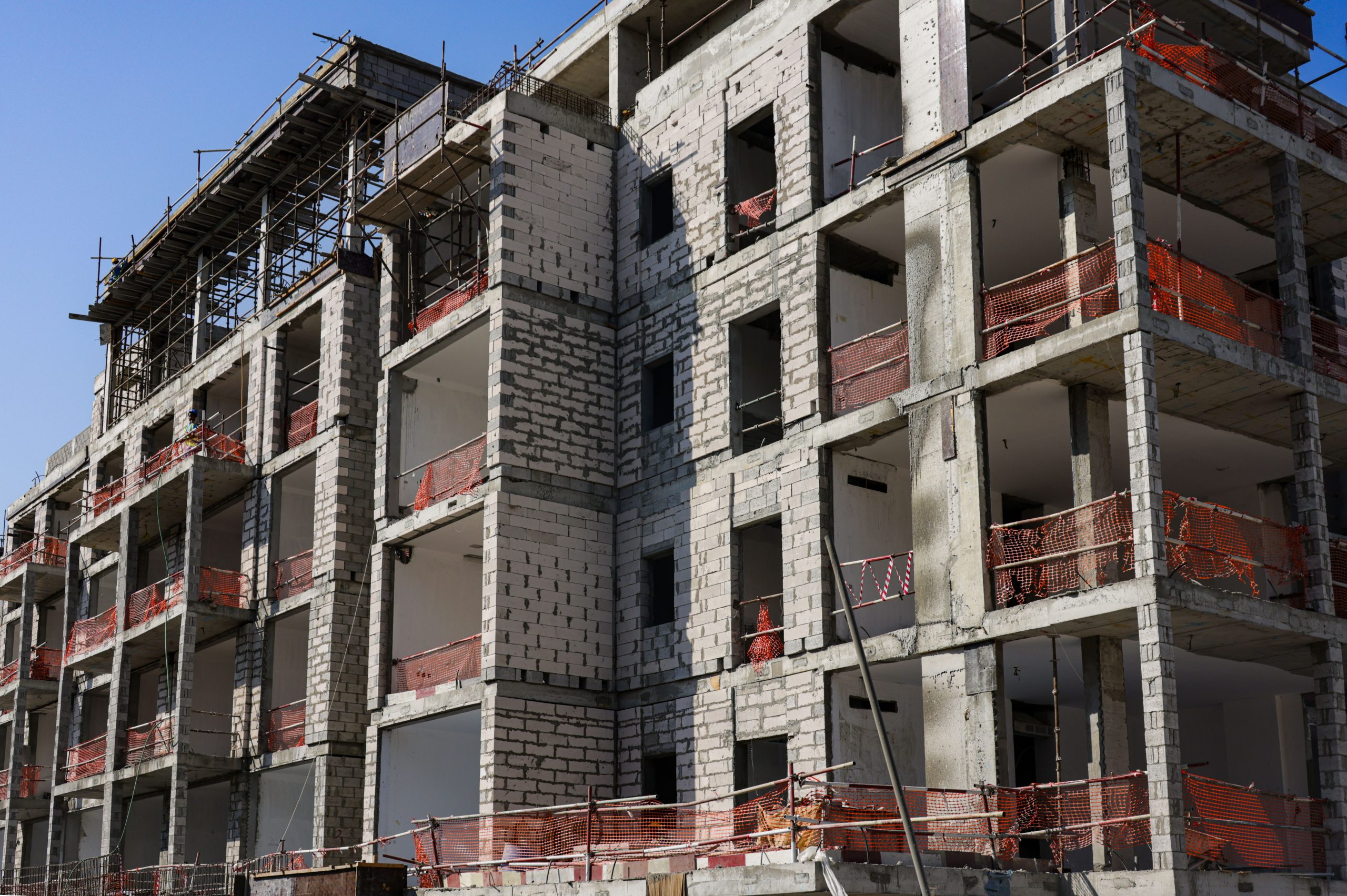 Immeuble en construction avec échafaudage et filets