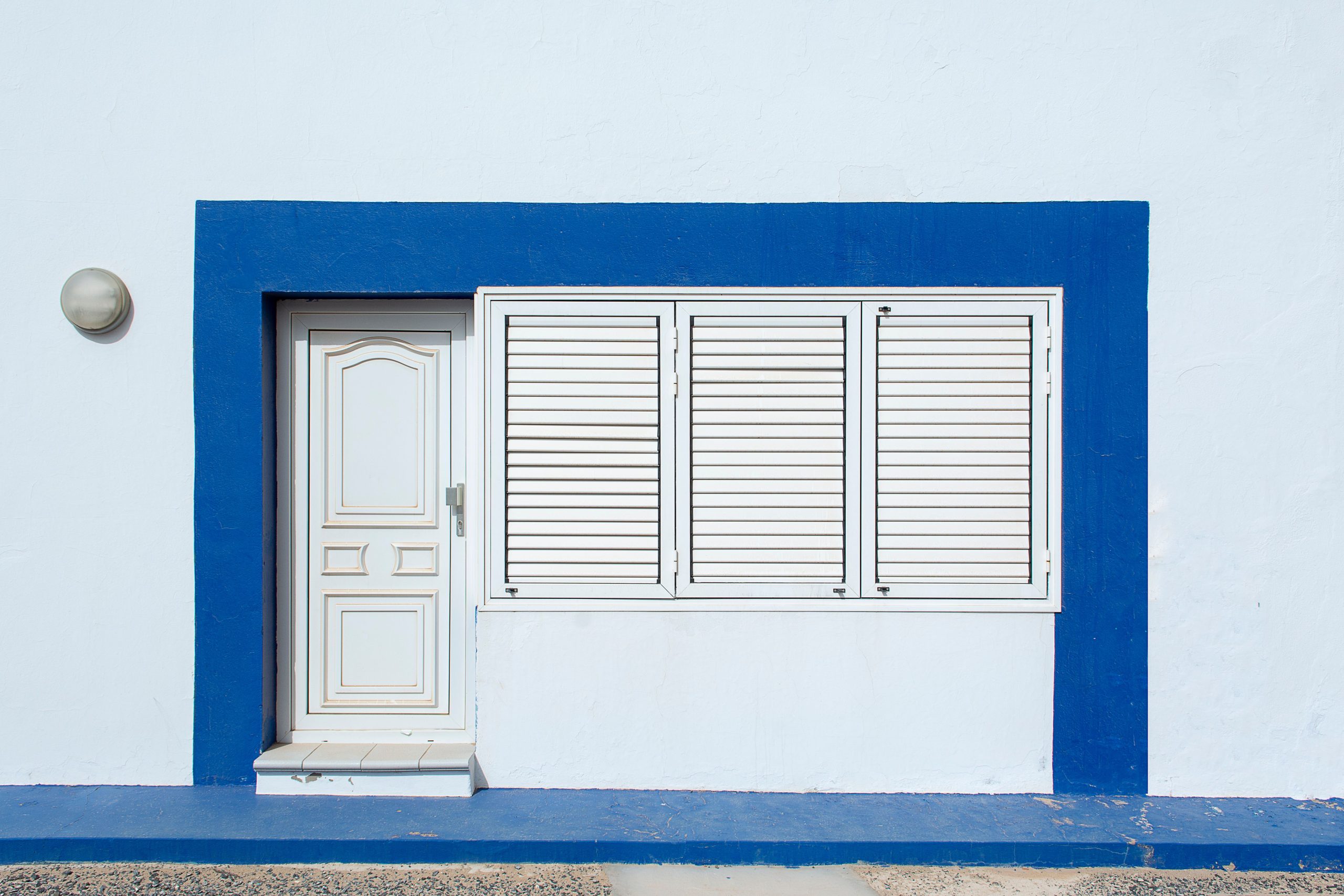 Façade blanche et bleue avec volets